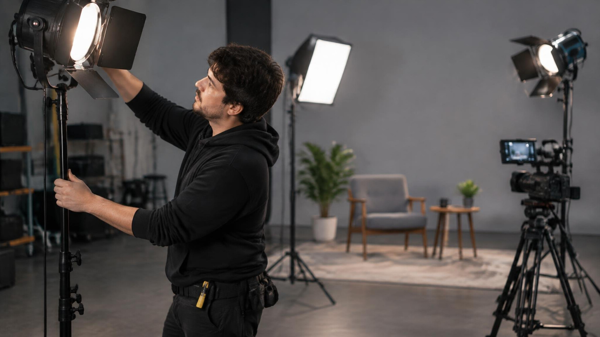 Person adjusting a three-point lighting setup on a film set