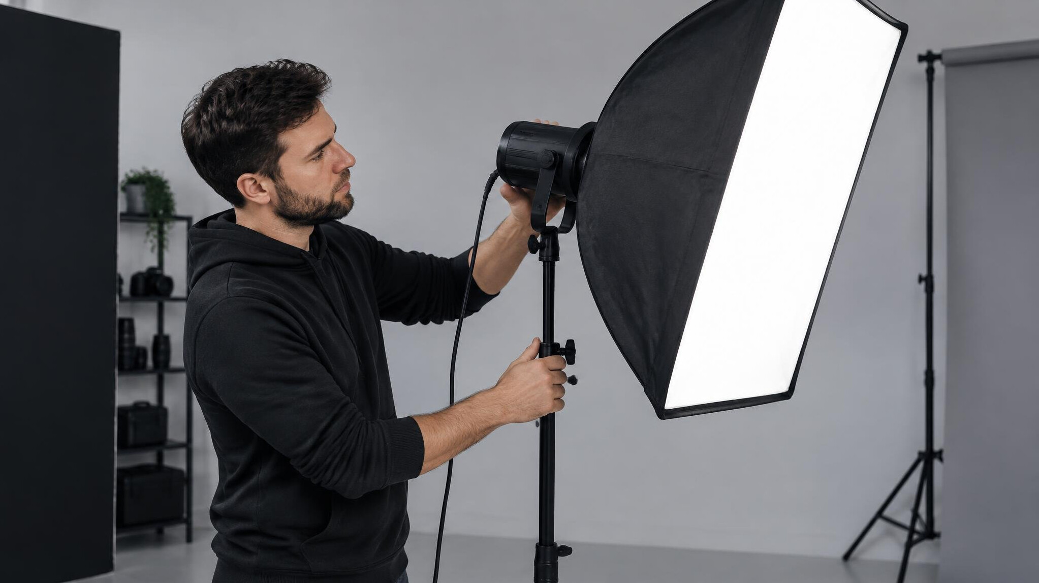 Person adjusting a softbox studio light